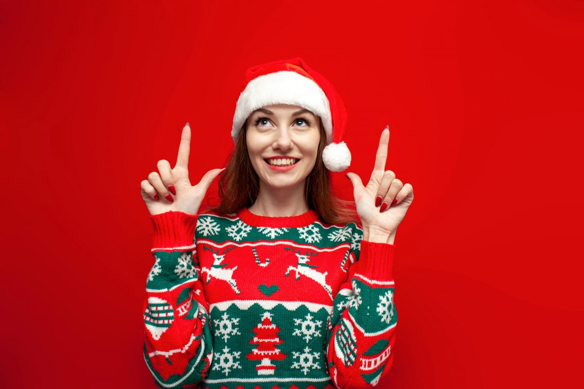 une fille avec un pull de noel est contente de son message d\'attente téléphonique